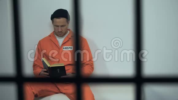 白种人囚犯在牢房里读圣经被定罪的罪人转向宗教视频的预览图