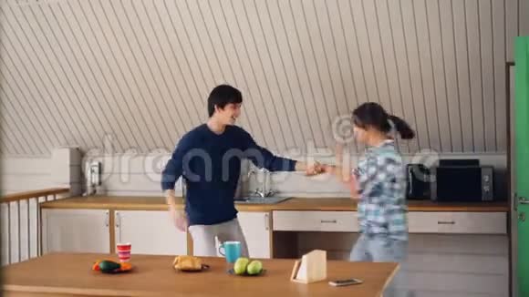 快乐的学生美丽的夫妇在厨房里跳舞一起玩一起欢笑享受闲暇时光视频的预览图