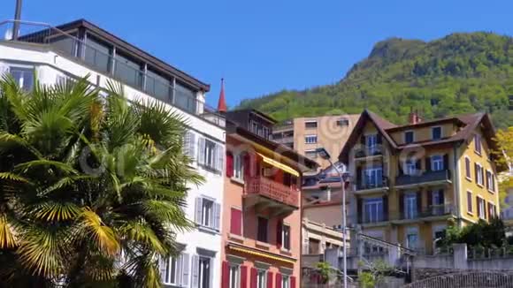 一个小镇的街道上山峦背景上美丽的多色瑞士房屋视频的预览图