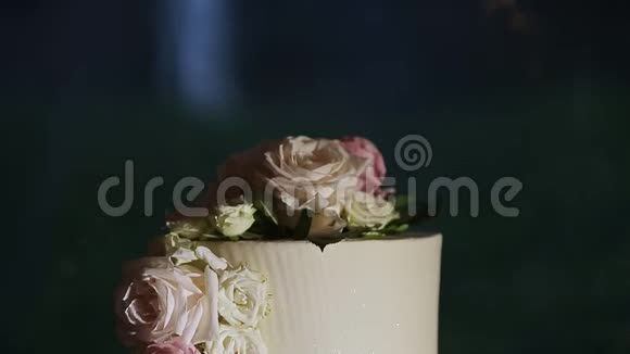 粉色玫瑰白色婚礼蛋糕上的特写全景视频的预览图