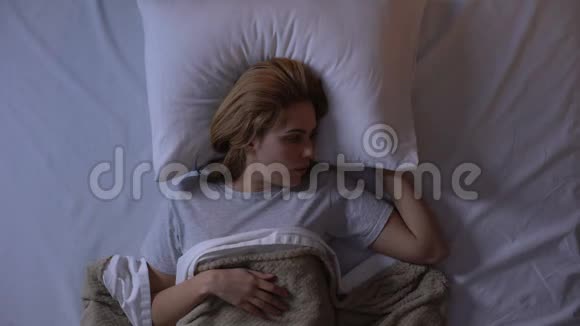 愤怒的女孩用枕头闭上耳朵吵闹的邻居打扰晚上睡觉视频的预览图