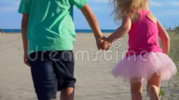 小男孩和小女孩沿着沙滩奔向大海视频的预览图