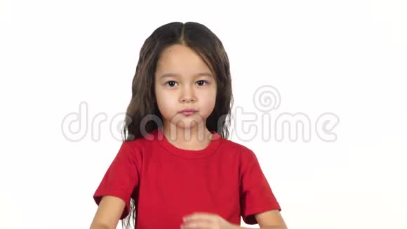 小女孩在白色背景下摆姿势的交叉手的肖像慢动作视频的预览图