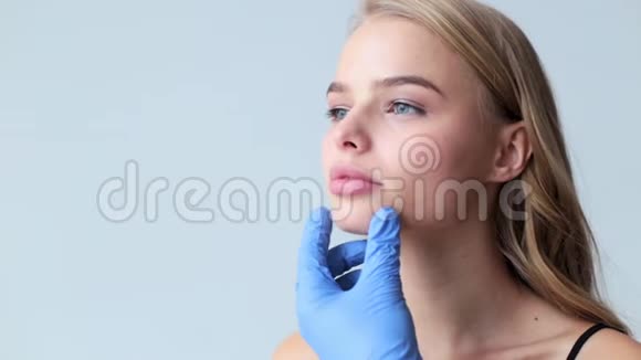 医生用注射器和女性漂亮的脸这位年轻迷人的女士正在进行扩唇手术视频的预览图