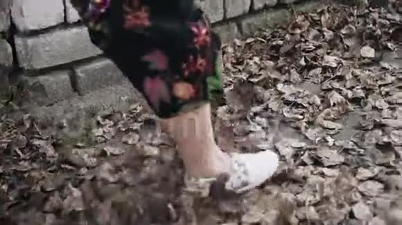 女孩的乐趣踢干秋叶路上很酷的搞笑镜头视频的预览图
