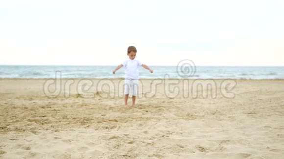 快乐的孩子慢悠悠地沿着沙滩奔跑视频的预览图