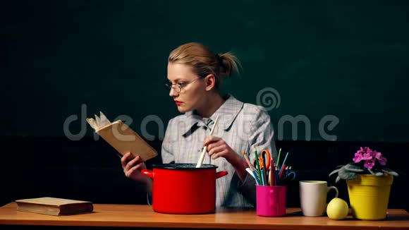有魅力的女人在做饭年轻女性烹饪的肖像与参考书籍隔离在绿板上烹饪视频的预览图
