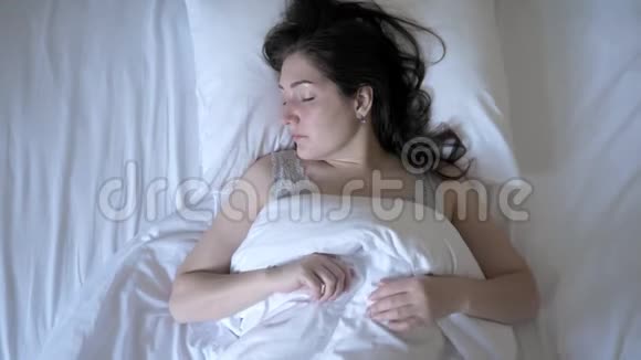 年轻的女人醒了留在床上早上在度假视频的预览图