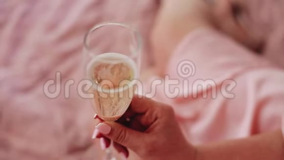 女孩拿着一杯酒特写镜头玻璃杯里的气泡视频的预览图