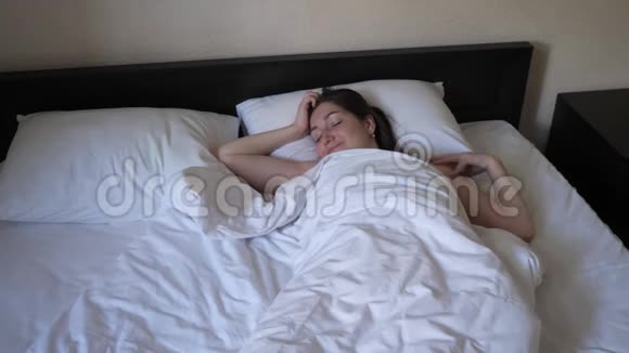 年轻的女人醒了留在床上早上在度假视频的预览图