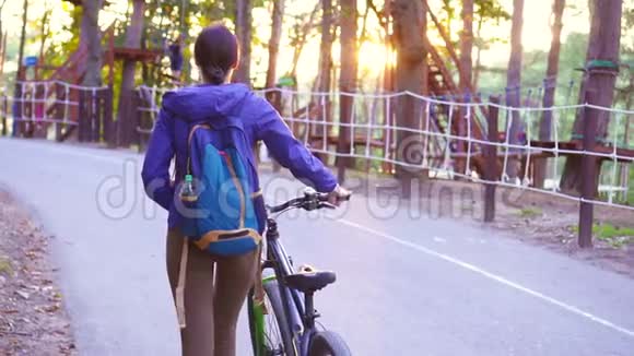 日落时女孩骑着自行车去公园视频的预览图