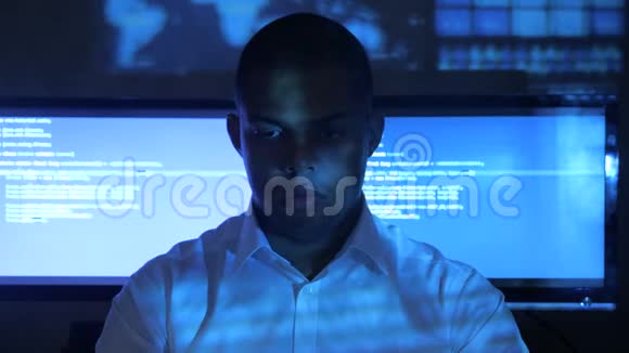 美国黑人男程序员穿着白色衬衫在安全数据中心的计算机上工作的肖像全息编码视频的预览图