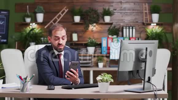 穿着正式西装的商人用手机进行视频对话的大镜头视频的预览图