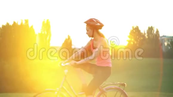 戴着头盔的女孩骑着自行车和城市的地平线视频的预览图