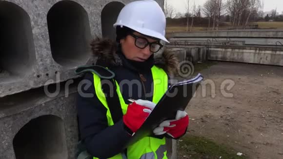 女工程师在混凝土块附近写作视频的预览图