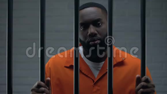 黑男囚犯在监狱里等待判决悲伤地看着镜头视频的预览图