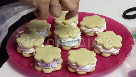 做一个棉花糖三明治女人从糕点袋里放巧克力准备棉花糖和饼干放在盘子里视频的预览图