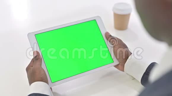 非洲男子看平板电脑与铬键屏幕视频的预览图