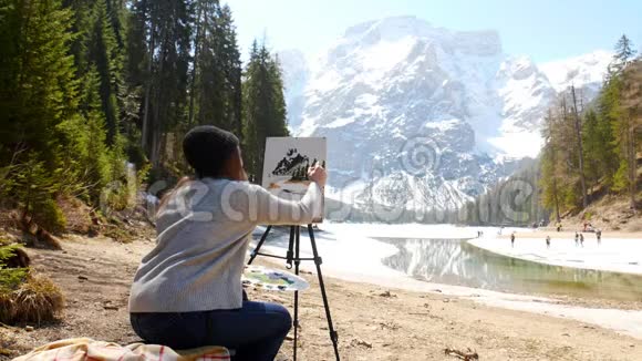 白云石一个年轻的女人画一幅关于自然的画画树视频的预览图