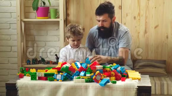 父子俩在玩塑料设计师家庭在家五彩缤纷的背景有胡子的人好父亲视频的预览图