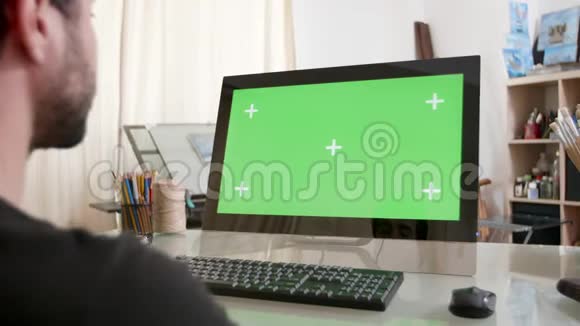 画家工作室的年轻人看着绿色的屏幕视频的预览图