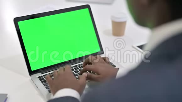 非洲商人使用带有Chroma键屏的笔记本电脑的后视图视频的预览图