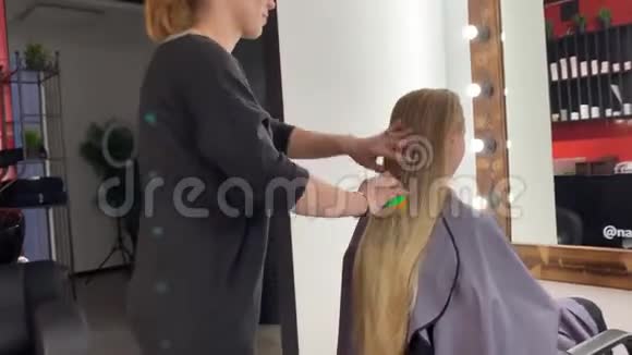 理发师编辫子的女人在美发沙龙头发视频的预览图
