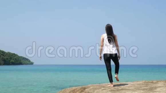 4K暑假期间一个女人单腿站在海上的木桥上练习瑜伽视频的预览图