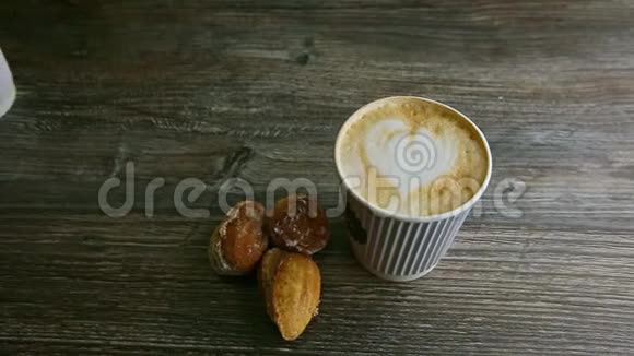男人的手把第二个咖啡杯放在另一个和杏仁饼干旁边视频的预览图