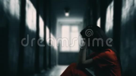 忧郁和沮丧的女人坐在黑暗的走廊里有背光和镜头照明悲伤的心情感到疲倦视频的预览图