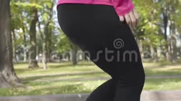 女白种人穿着运动裤的腿的特写镜头在跑步过程中由于膝盖疼痛而停止女跑步者视频的预览图
