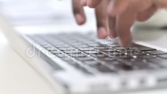 非洲男子在笔记本电脑键盘上打字的手指正面图视频的预览图