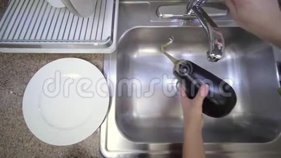 女人正在厨房的水槽里用自来水洗茄子视频的预览图
