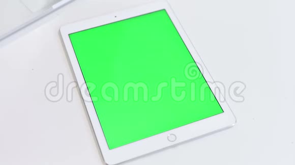 白色桌面上带有彩色按键屏幕的平板的顶部视图视频的预览图