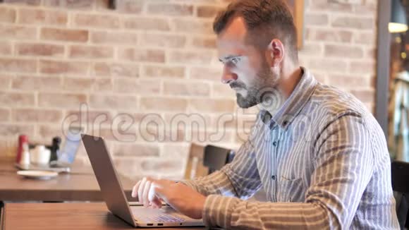 在阁楼的笔记本电脑上男人对结果感到沮丧视频的预览图