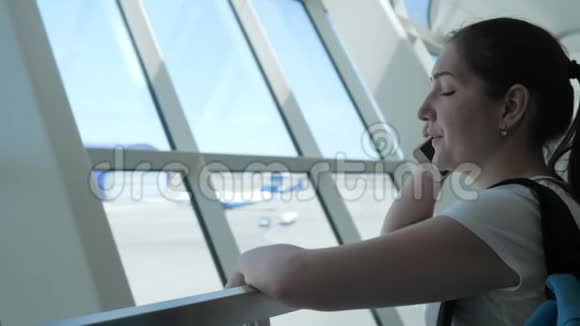 年轻女子正在飞行区机场候机楼用手机交谈视频的预览图