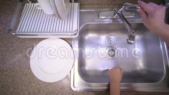 女人正在厨房的水槽里用自来水洗茄子视频的预览图