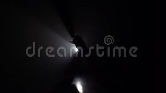 男性在黑暗中练习卡波埃拉在灯光下慢动作视频的预览图