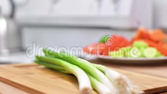 女人用菜刀在木板上切新鲜的洋葱视频的预览图
