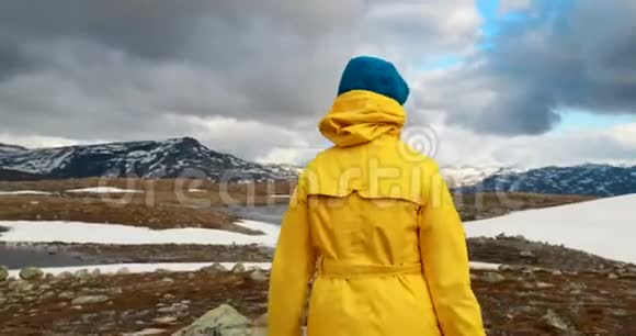 挪威奥兰兹菲杰莱幸福的年轻女性游客在Aurlandsfjellet风景区公路附近散步视频的预览图
