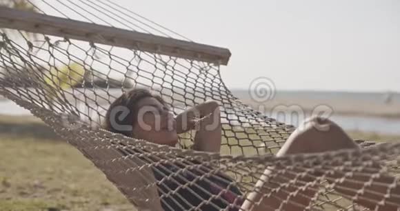 女自由职业者在海滩吊床异国情调放松生活方式广告商业概念佳能近景视频的预览图