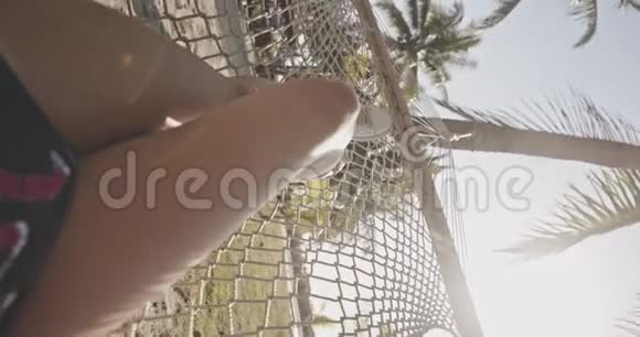 垂直视频快乐的女人放松在吊床上的热带海滩异国情调放松生活方式广告商业视频的预览图