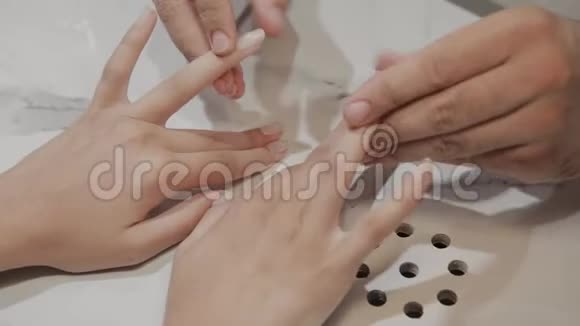 专业大师在修指甲后按摩女孩的手指视频的预览图