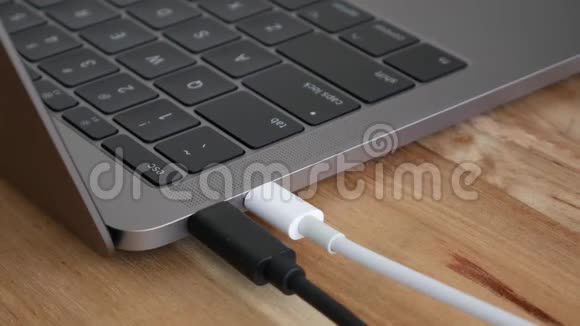 男性手在白色电源USBC或C型电线和黑色闪存驱动器电缆插入笔记本电脑USBC视频的预览图