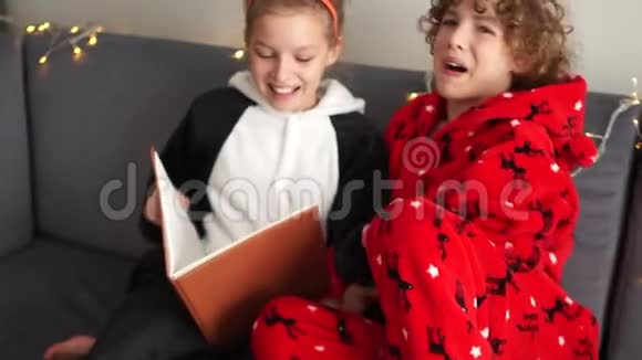 圣诞睡衣快乐的孩子们在圣诞节前的晚上读了一本书家庭幸福新年快乐视频的预览图