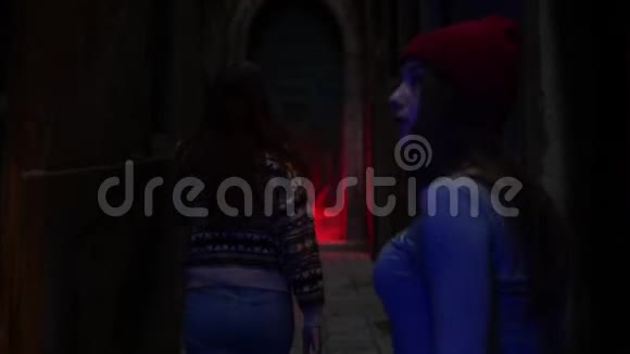 两位年轻的女性研究人员走在黑暗古老神秘危险的走廊上视频的预览图