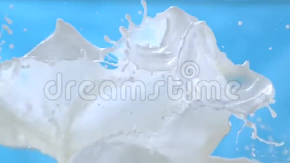 在1500fps的慢动作中牛奶波在蓝色背景上飞溅视频的预览图