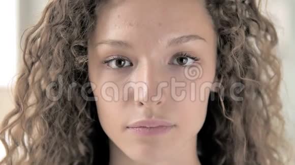 一脸严肃的卷发女人视频的预览图