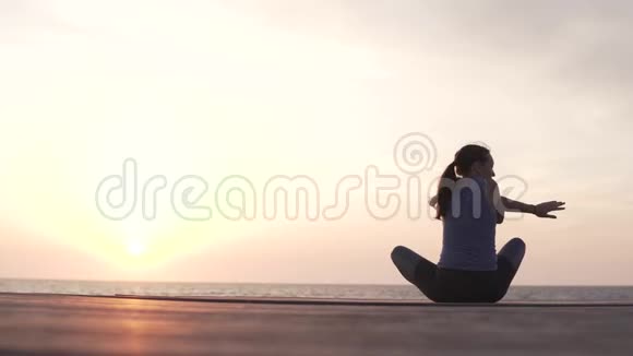 女人做瑜伽在海里看日落视频的预览图