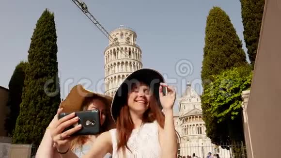 意大利比萨两个年轻微笑的女人在巴拿马站在比萨斜塔的背景上带着一个视频的预览图